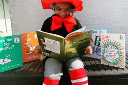 Child reading with books around them
