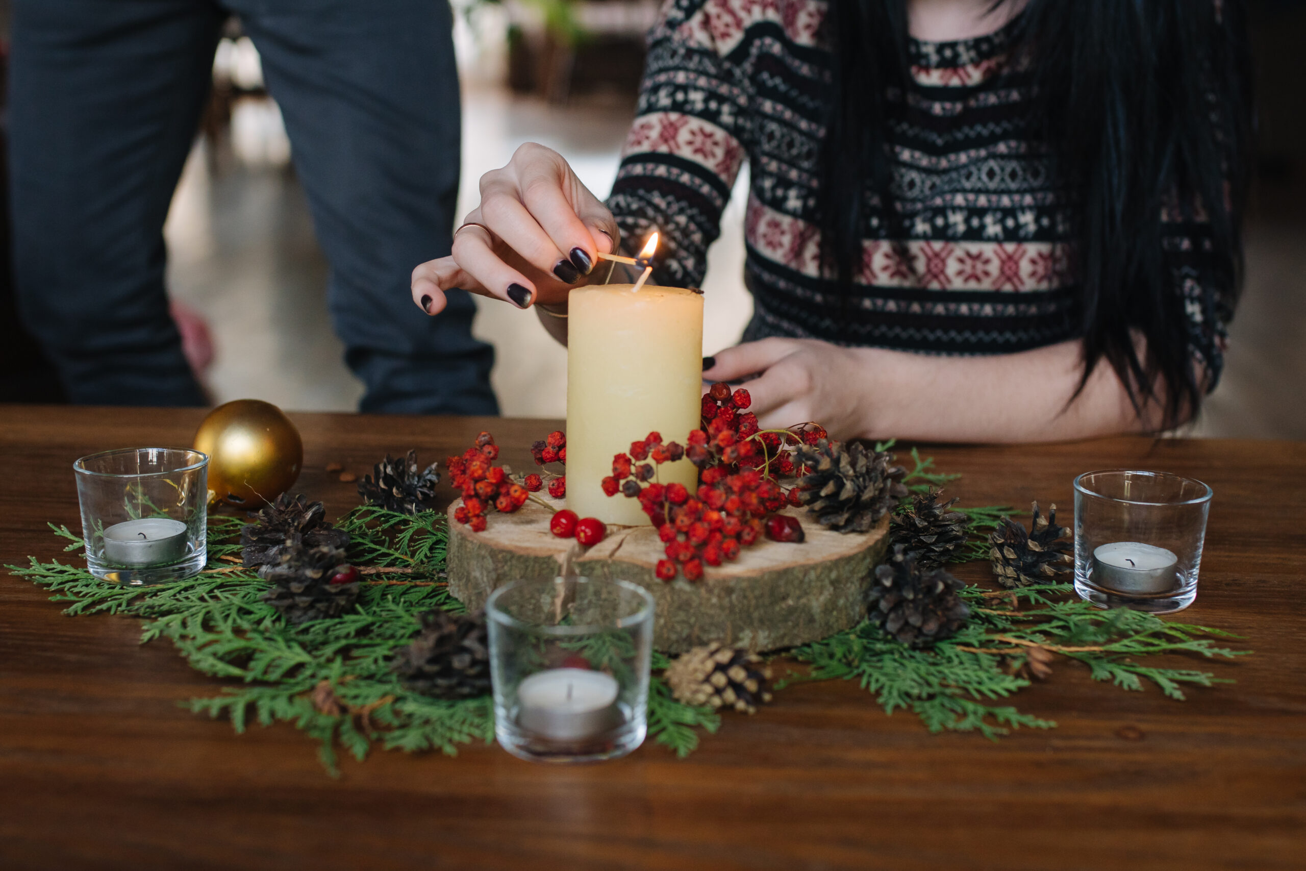 Women lighting an advent candle at Christmas