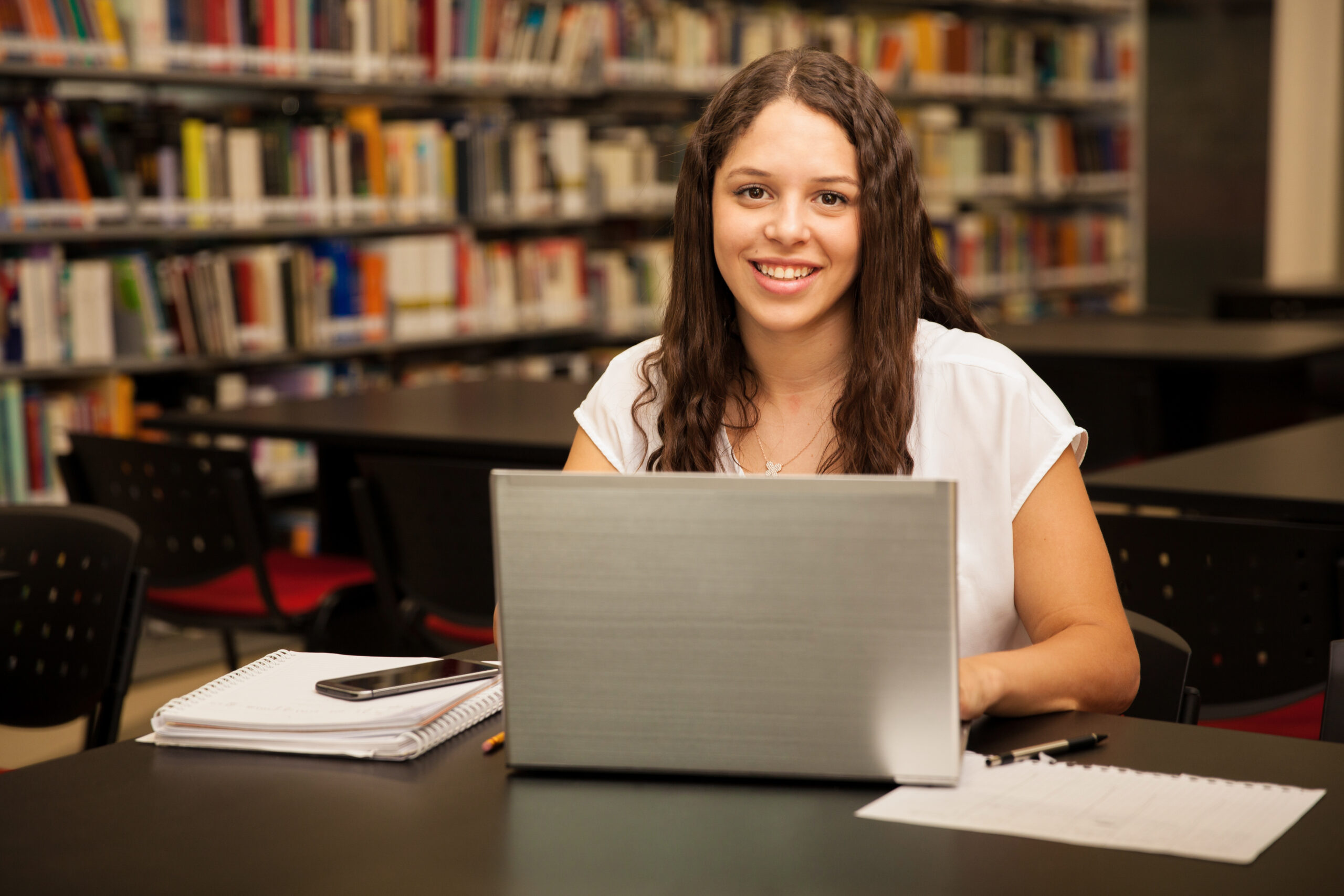 Student on laptop smiling at camera